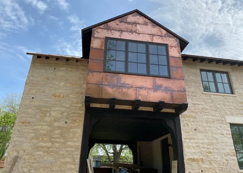 Copper metal panel facade on a stone building for Roof Repair in Hingham